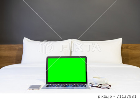 Laptop computer with blank white screen with smartphone,coffee cup and spectacles on white bed decoration in hotel bedroom interior background,Work and business in leisure with travel in the holiday. Laptop computer with blank white screen with smartphone,coffee cup and spectacles on white bed decoration in hotel bedroom interior background,Work and business in leisure with travel in the holiday. 71127931