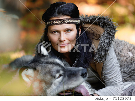 Portrait of a nice woman with an Alaskan Malamute dog in the autumn forest 71128972
