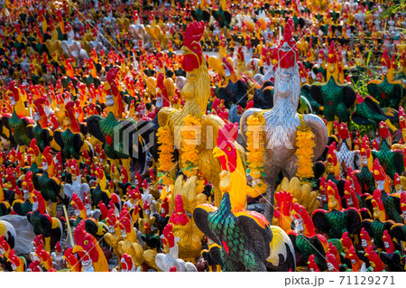 Chicken statues of various colors and sizes that people worship in the mystery of their beliefs. 71129271