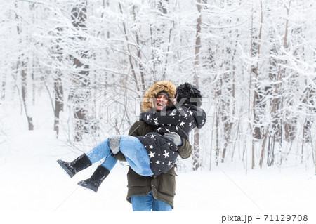 Young couple have fun in a snowy park. Winter season. 71129708