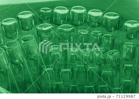 Glass medical ampoule vial for injection. Medicine is liquid sodium chloride with of aqueous solution in ampulla. Close up. Bottles ampule multicolor. 71129987