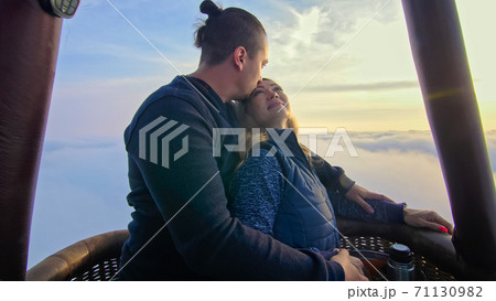 Adventure love couple on hot air balloon watermelon. Man and woman kiss hug love each other. Burner directing flame into envelope. Happy people. Adventure love couple on hot air balloon watermelon. Man and woman kiss hug love each other. Burner directing flame into envelope. Happy people. 71130982