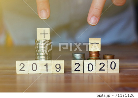 business man pointing his fingers to stack of coins and plus sign ,minus sign world economic. business concept. business man pointing his fingers to stack of coins and plus sign ,minus sign world economic. business concept. 71131126