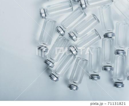 Glass medical ampoule vial for injection. Medicine is dry white drug penicillin powder or liquid with of aqueous solution in ampulla. Close up. 71131821