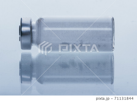 Glass medical ampoule vial for injection. Medicine is dry white drug penicillin powder or liquid with of aqueous solution in ampulla. Close up. Glass medical ampoule vial for injection. Medicine is dry white drug penicillin powder or liquid with of aqueous solution in ampulla. Close up. 71131844