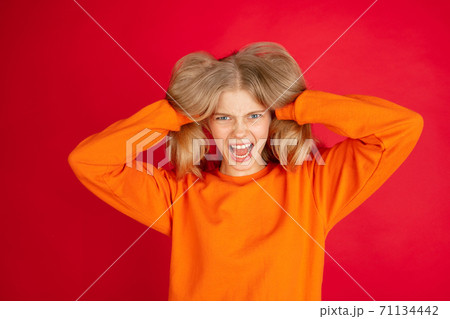 Portrait of young caucasian woman with bright emotions isolated on red studio background Portrait of young caucasian woman with bright emotions isolated on red studio background 71134442