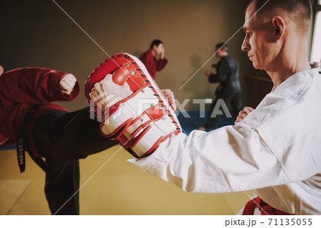 Man holding a glove for kick training.  71135055