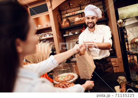Young Man Selling Bread to Customer in Bakery. Young Man Selling Bread to Customer in Bakery. 71135225