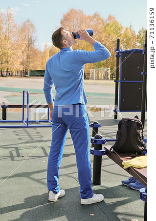 toned slim man of middle age drinking whey protein cocktail 71136159