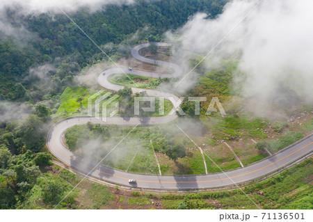 Aerial view of cars driving on curved, zigzag curve road or street on mountain hill with green natural forest trees in rural area of Phu Tub Berk, Phetchabun, Thailand. 71136501