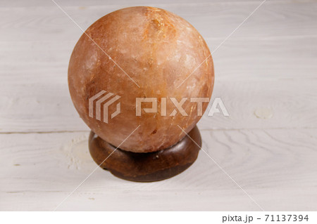 Himalayan salt lamp on white wooden background Himalayan salt lamp on white wooden background 71137394