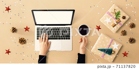 Christmas ornaments with person using a laptop computer 71137820