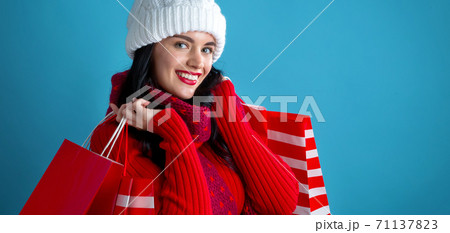 Happy young woman holding shopping bags 71137823