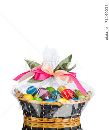 Easter gift basket with multicolor eggs, isolated on white 71140032