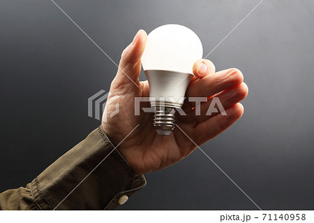 Included led new lamp in human hand on dark background 71140958