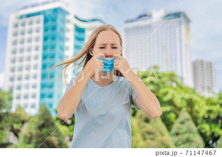 Improper wearing of mask concept. Woman scratching his nose under the mask, touches the mask Improper wearing of mask concept. Woman scratching his nose under the mask, touches the mask 71147467
