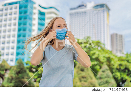 Improper wearing of mask concept. Woman scratching his nose under the mask, touches the mask 71147468