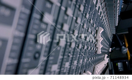 Close up of male sound engineer moves buttons of soundboard. Shot. Arms of man working on professional digital audio channel mixer. Amplifier and balance of sound. 71148934