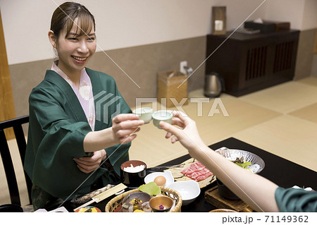 旅館夕食時おちょこで乾杯する女性客　女子旅　GoToトラベルイメージ 71149362