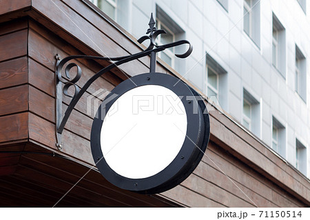 Blank minimal circular shop signboard mockup for design. Street hanging sign board for logo presentation mounted on the wall. Metal cafe restaurant or bar badge black white round. 71150514