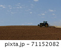 青空の下で働くトラクター 71152082