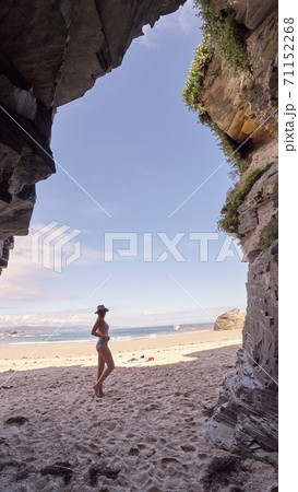Young woman contemplating a cave made of rocks in Galicia, Spain Young woman contemplating a cave made of rocks in Galicia, Spain 71152268