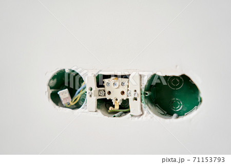 Three sockets. Installation high voltage. Electrical wires sticking out of an electrical outlet on a concrete wall, decorative plaster, apartment renovation. Three sockets. Installation high voltage. Electrical wires sticking out of an electrical outlet on a concrete wall, decorative plaster, apartment renovation. 71153793