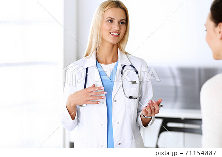 Doctor woman at work in hospital excited and happy of consulting female patient. Blonde physician controls medication history records and exam results while using clipboard. Medicine and healthcare Doctor woman at work in hospital excited and happy of consulting female patient. Blonde physician controls medication history records and exam results while using clipboard. Medicine and healthcare 71154887