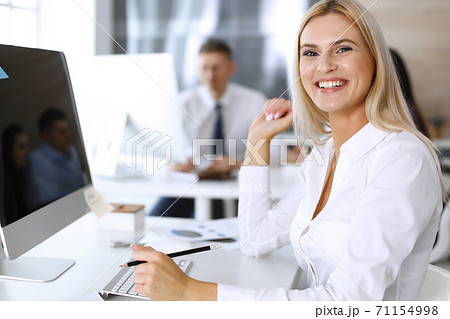 Business woman looks happy and excited at workplace in modern office. Secretary or female lawyer working for pleasure and success 71154998