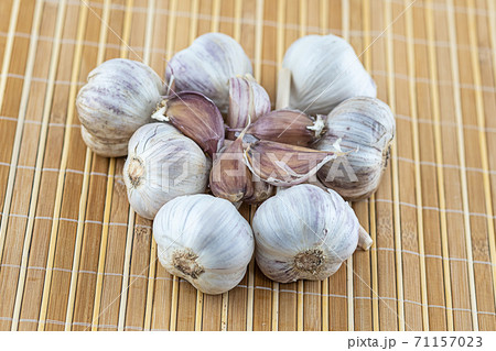 set the head of garlic in the center of a clove on a wooden mat 71157023