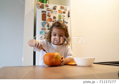 Happy toddler child with carved pumpkin at home. Halloween activities with kids 71157277