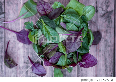 Mixed Salad leaves in a glass bowl on wooden background. 71157518