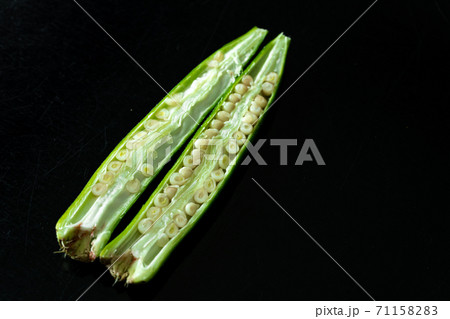 Green tropical vegetable called ladies' fingers or ochro on black background Green tropical vegetable called ladies' fingers or ochro on black background 71158283