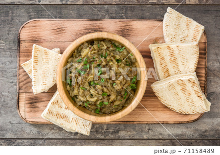 Baba ganoush in wooden bowl and pita bread on wooden table. Top view 71158489