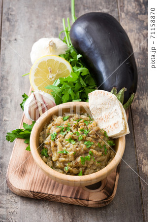 Eggplant baba ganoush and ingredients on wooden table Eggplant baba ganoush and ingredients on wooden table 71158870