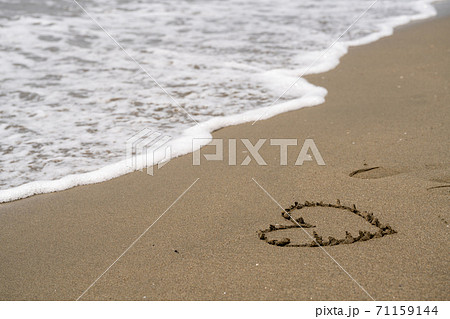 砂浜 ハート 波 海の写真素材