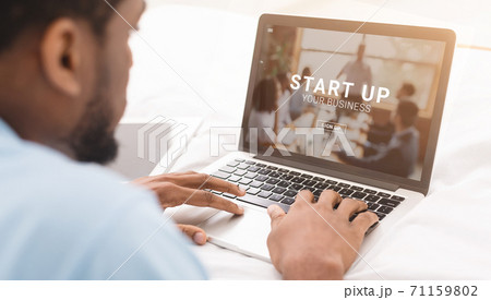 African American entrepreneur working on laptop computer with START UP YOUR BUSINESS website on screen, collage 71159802