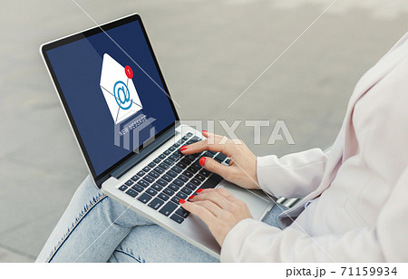Businesswoman With Laptop Reading E-Mail Message Communicating Online Sitting Outdoors 71159934