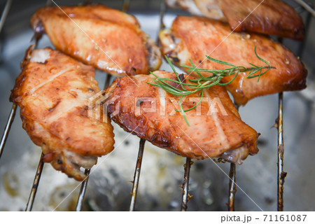 chicken wings grilled on grill with sauce herbs and spices cooking thai asian food rosemary chicken  / chicken wings grilled on grill with sauce herbs and spices cooking thai asian food rosemary chicken  / 71161087