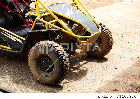 Muddy Buggy Parked in the Parking Lot After a Heavy Dirt Race. 71162826