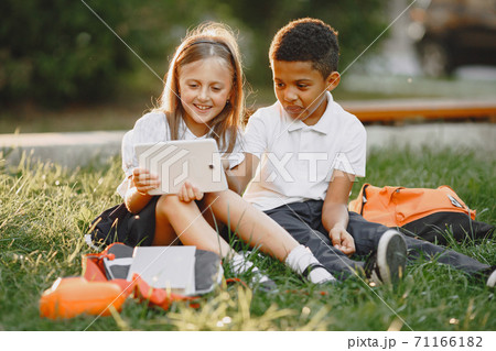 Little african boy study with caucasian girl 71166182