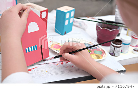 teenager girl's hands painting wooden toy house. teenager girl's hands painting wooden toy house. 71167947