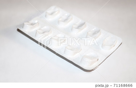 Pharmacy drugstore concept. Packs of white pills packed in blisters with copy space isolated on a white background. Focus on foreground, soft bokeh. Pharmacy drugstore concept. Packs of white pills packed in blisters with copy space isolated on a white background. Focus on foreground, soft bokeh. 71168666