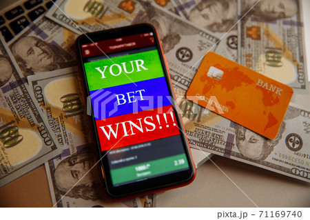 Smartphone with gambling mobile application and debit card on dollar banknotes Smartphone with gambling mobile application and debit card on dollar banknotes 71169740