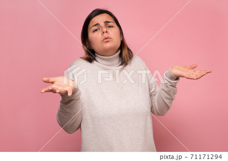 Beautiful caucasian doubtful woman shrugs her shoulders. 71171294