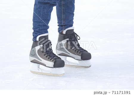 Legs of a man skating on an ice rink. Hobbies and sports. Vacations and winter activities. Legs of a man skating on an ice rink. Hobbies and sports. Vacations and winter activities. 71171391