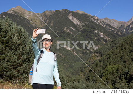 Young tourist woman take a picture from mountain with mobile phone Young tourist woman take a picture from mountain with mobile phone 71171857