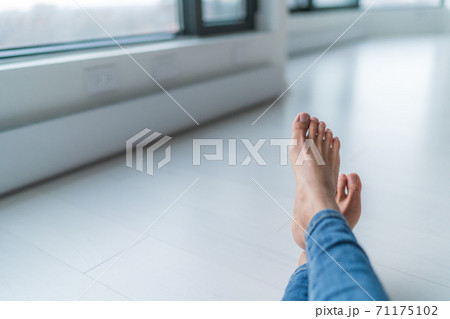 Home relax comfort lifestyle woman barefoot relaxing at warm radiators heat system in apartment or condo living. Cozy winter electric baseboards in house. Closeup of feet Home relax comfort lifestyle woman barefoot relaxing at warm radiators heat system in apartment or condo living. Cozy winter electric baseboards in house. Closeup of feet 71175102