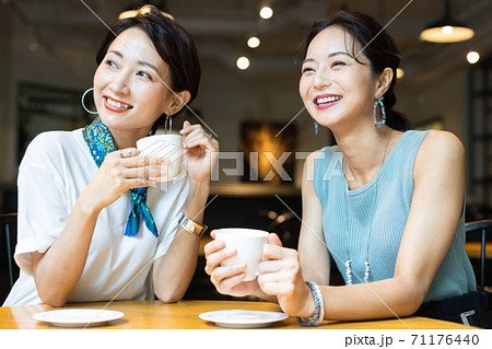 カフェで友達とお喋りする女性 カフェで友達とお喋りする女性 71176440
