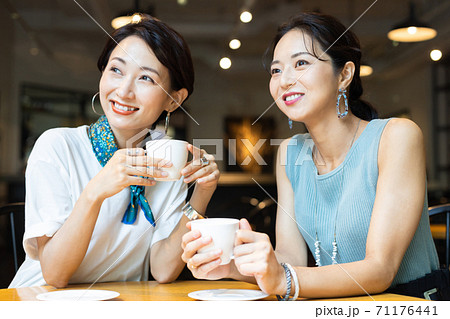 カフェで友達とお喋りする女性 カフェで友達とお喋りする女性 71176441